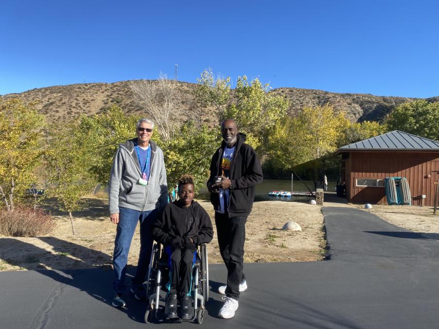 James, his dad, and his family Pal posing for a photo in front of Boating