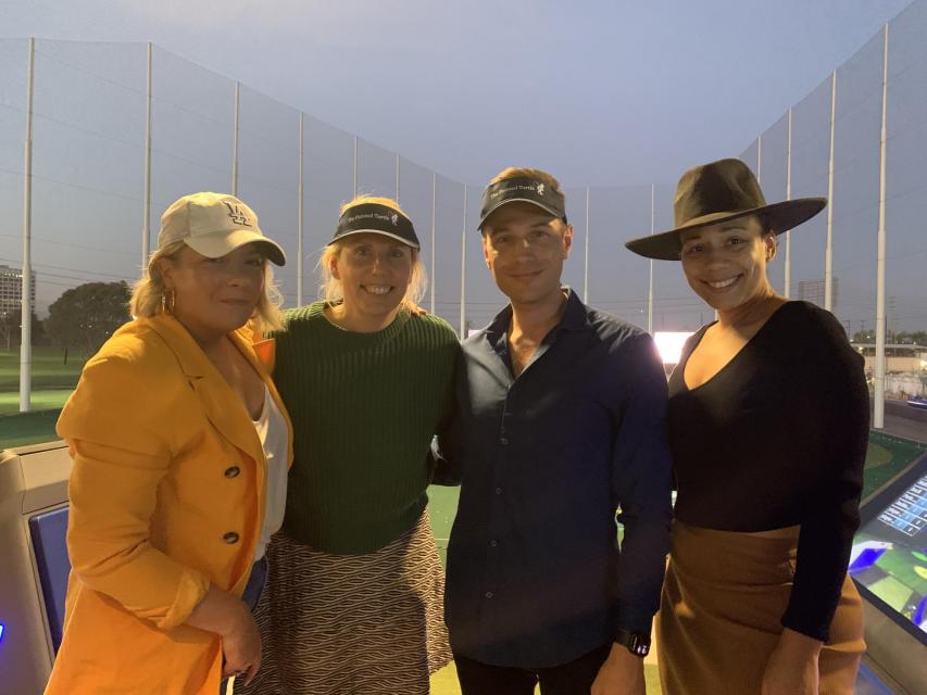 Four friends pose for a photo at Topgolf