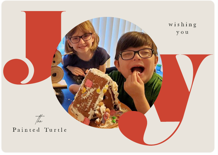 Holiday Card, Two Children making a ginger bread house with the message "Joy" around it. 