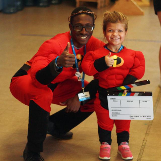 Summer staff positions, staff member with camper giving thumbs up!