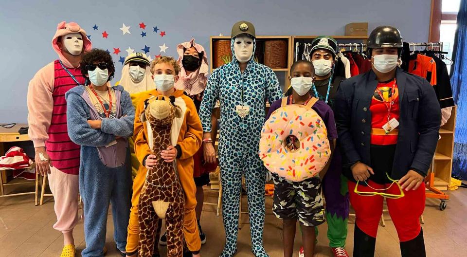 A group of campers and counselors in costumes at creative arts