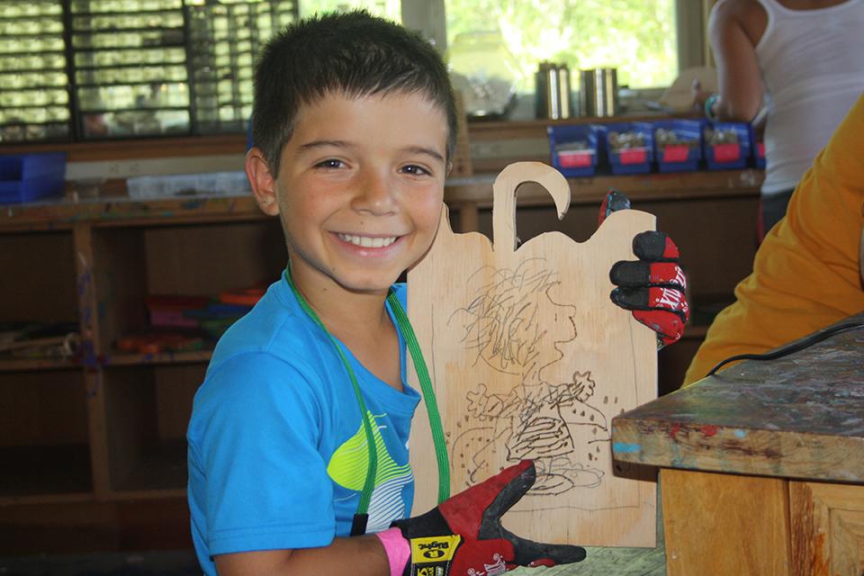Boy holding woodshop project 