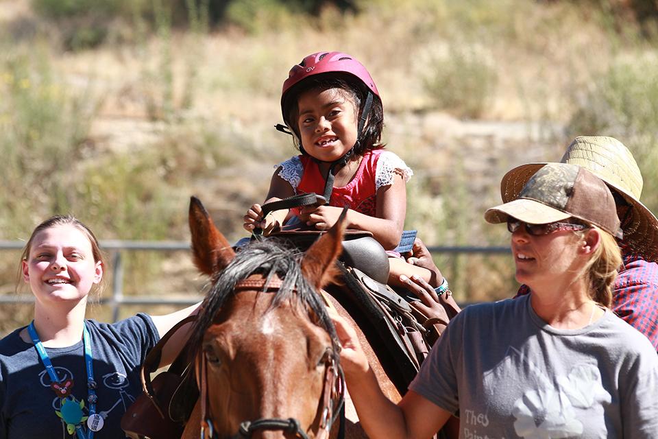Girl, enjoying horseback riding.
