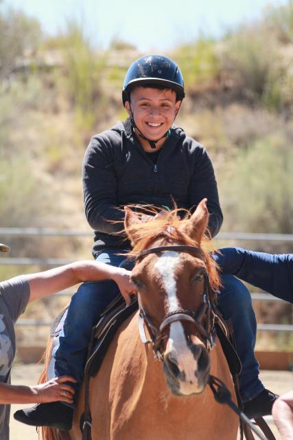 Boy enjoying horseback riding.