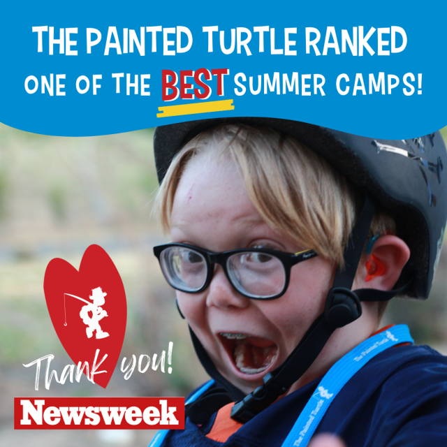 Young boy wearing glasses and a ropes course helmet expresses "Wow" as Painted Turtle announces ranking of being in the top summer camps for 2023